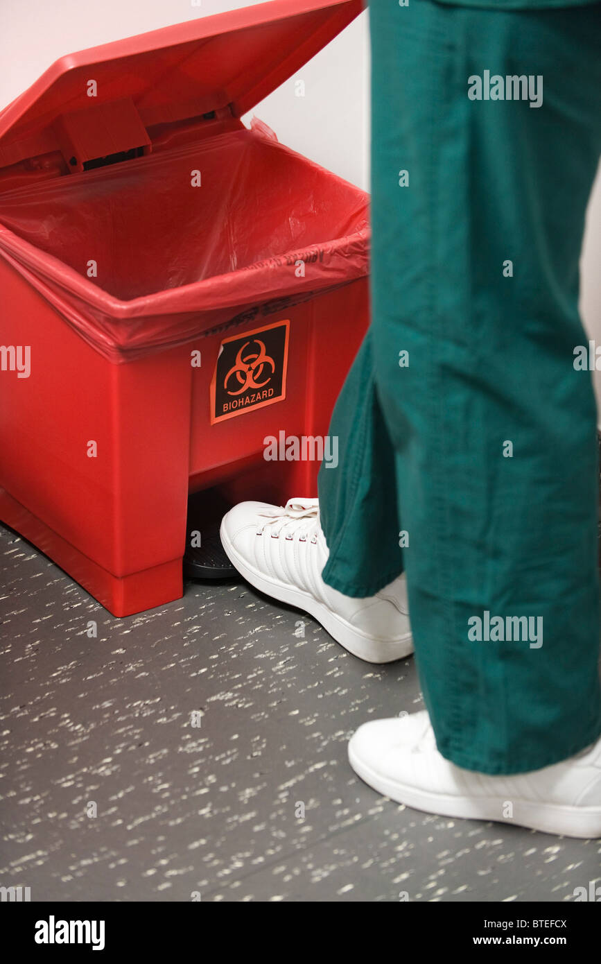 Jeter les déchets médicaux dans biohazard poubelle Photo Stock - Alamy