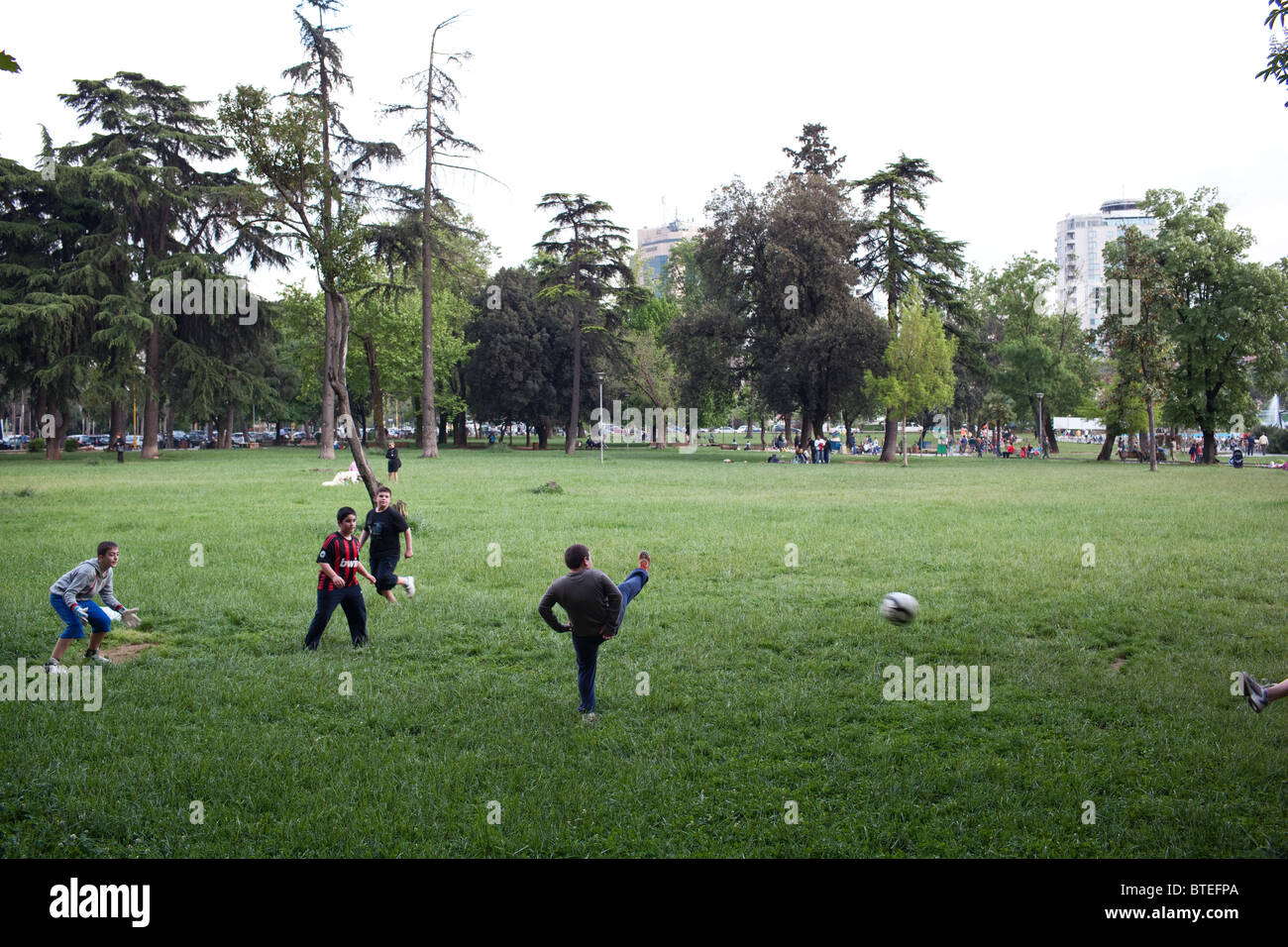 Un groupe de garçons jouent au football dans un parc à Tirana, la capitale de l'Albanie. Banque D'Images