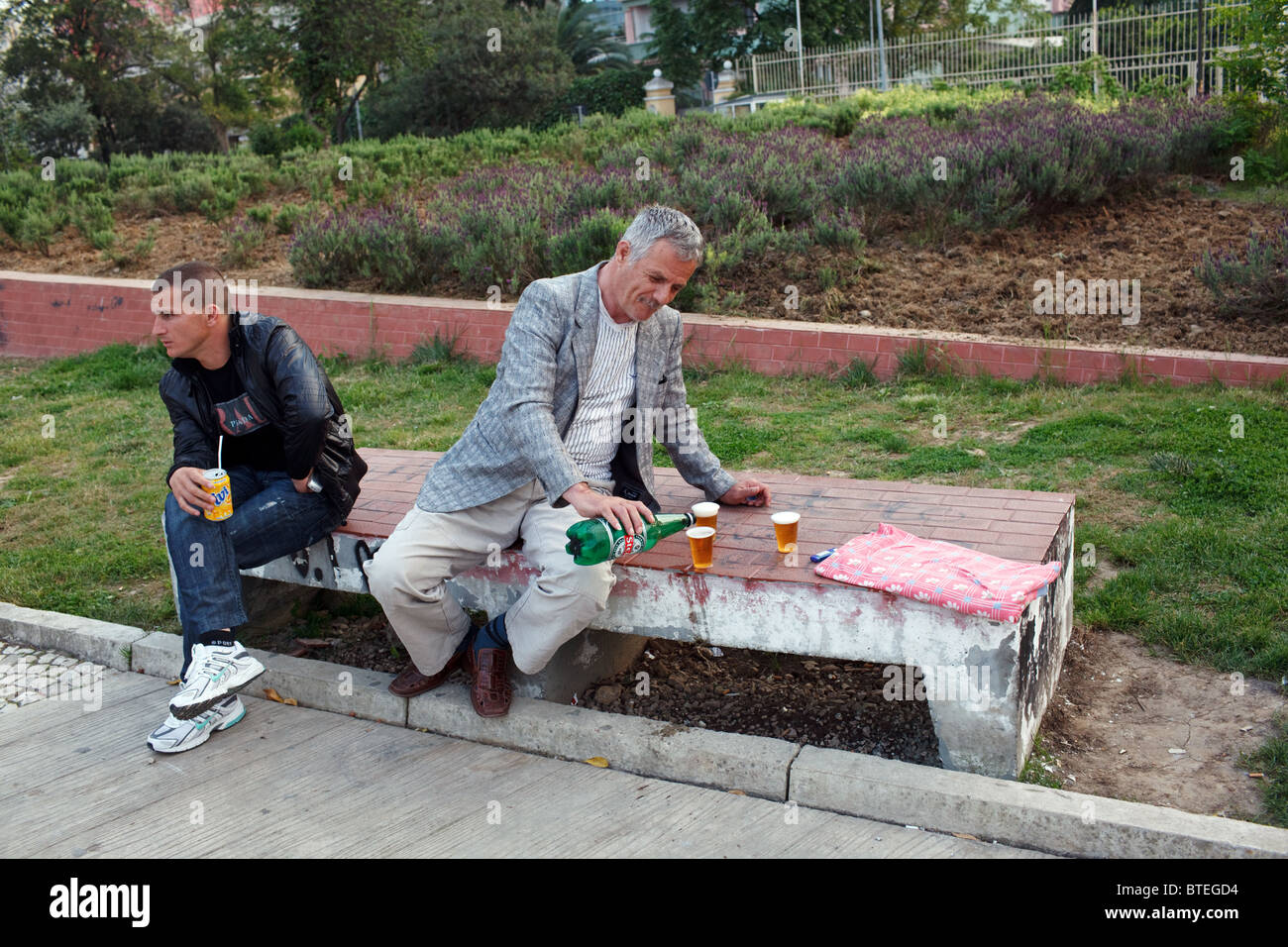 Un homme verse de la bière dans un parc à Tirana, la capitale de l'Albanie. Banque D'Images