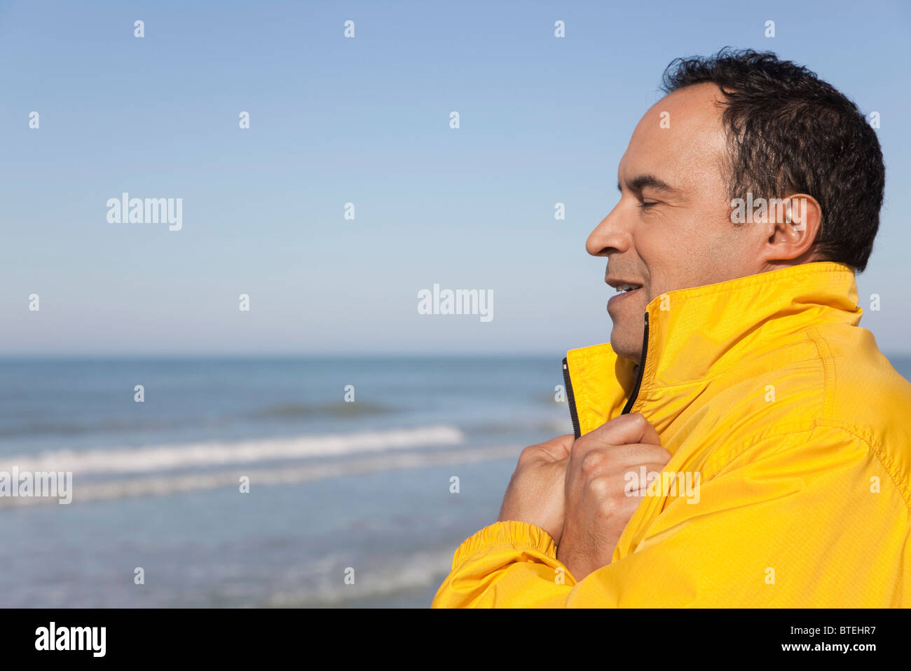 Homme mature à la plage sur un jour froid, les yeux clos, portrait Banque D'Images