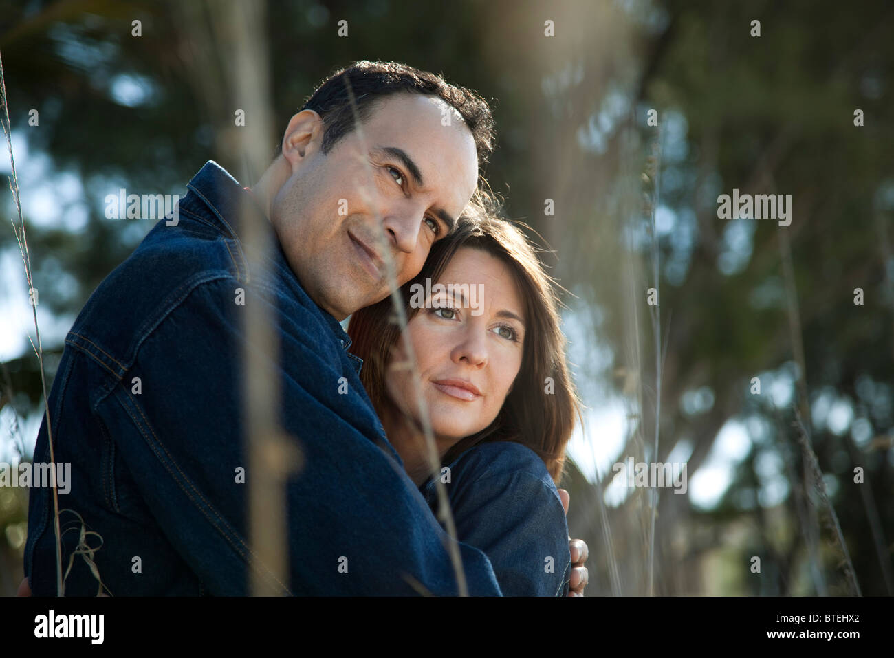 Young couple embracing outdoors, portrait Banque D'Images