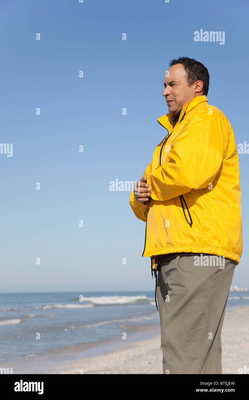 Man Standing on beach looking at Ocean Banque D'Images