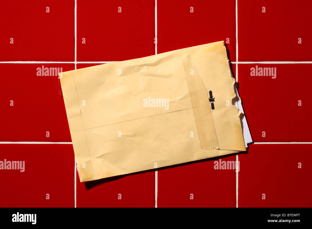 Une enveloppe postale postal utilisé à ouvrir. Arrière-plan de tuile rouge Banque D'Images