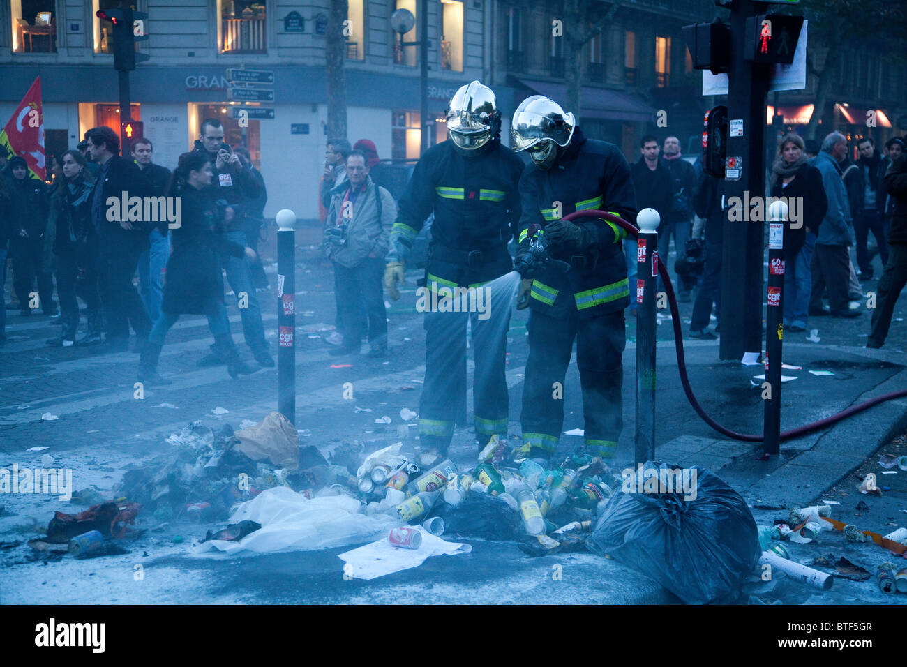 Pompiers Pompiers éteindre un feu a commencé par des manifestants au cours de la démonstration contre de nouvelles réformes des retraites, Paris, France, 28/10/10 Banque D'Images