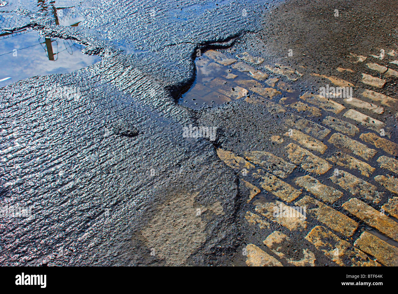 Pavé en pierre apparente d'une autre époque dans l'attente de la réfection de la route après une pluie. Banque D'Images