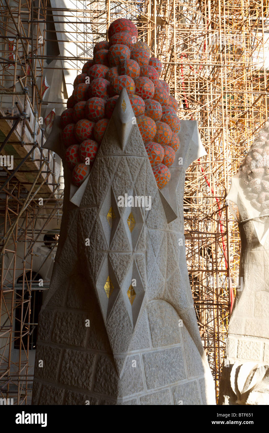 Cathédrale de la Sagrada Familia de Gaudi - détail d'un pinacle inspiré par des fruits, avec l'échafaudage derrière elle Banque D'Images