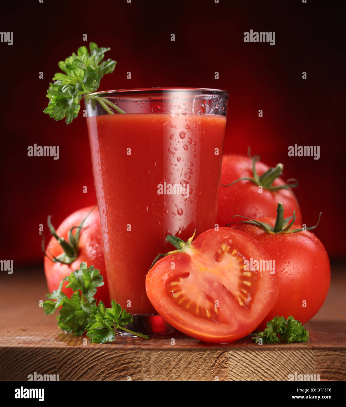 La nature morte de tomates fraîches et des jus de fruits sur une table en bois. Banque D'Images