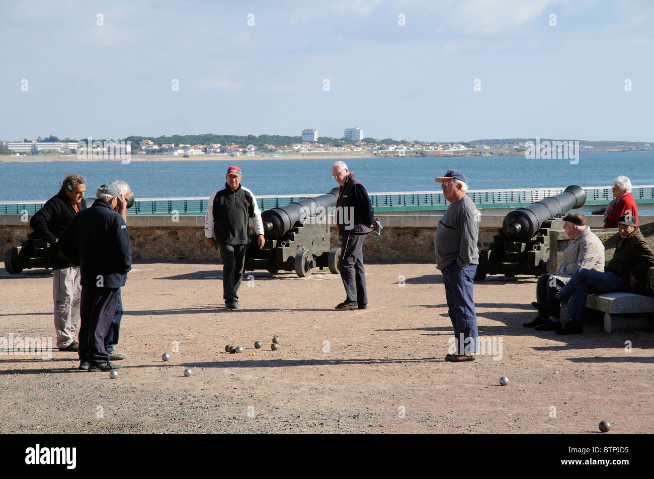 Les hommes jouant pétanque sur le front de mer de la Chaume avec une toile de fond des Sables d' Olonne en Vendée de France Banque D'Images