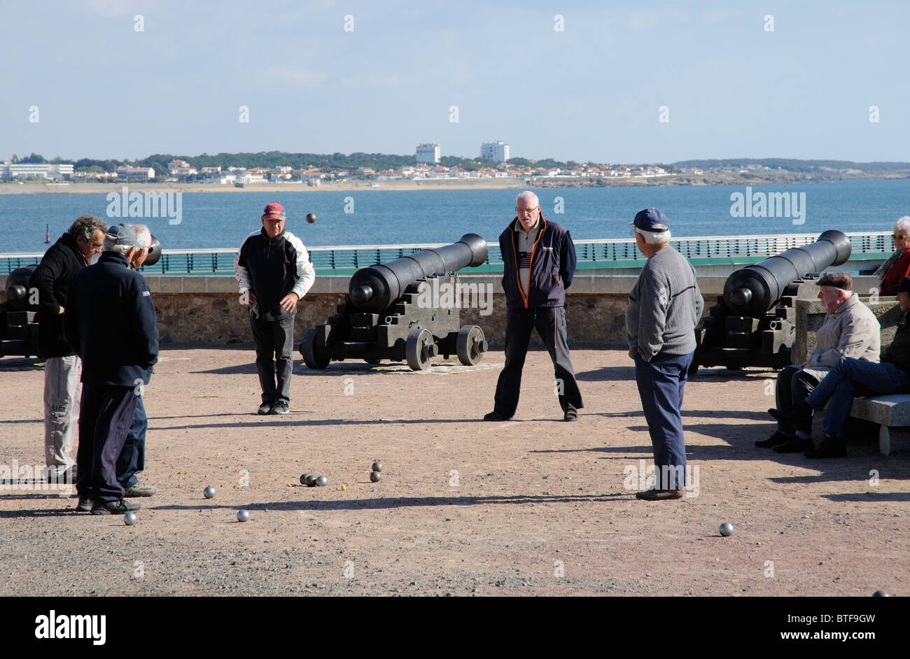 Les hommes jouant pétanque sur le front de mer de la Chaume avec une toile de fond des Sables d' Olonne en Vendée de France Banque D'Images
