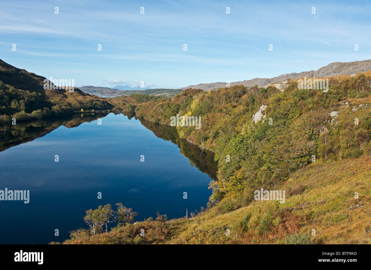 Les réflexions dans le Loch près de Dubhe Polnish à West Highlands d'Ecosse avec les montagnes de rhum dans le fond. Banque D'Images