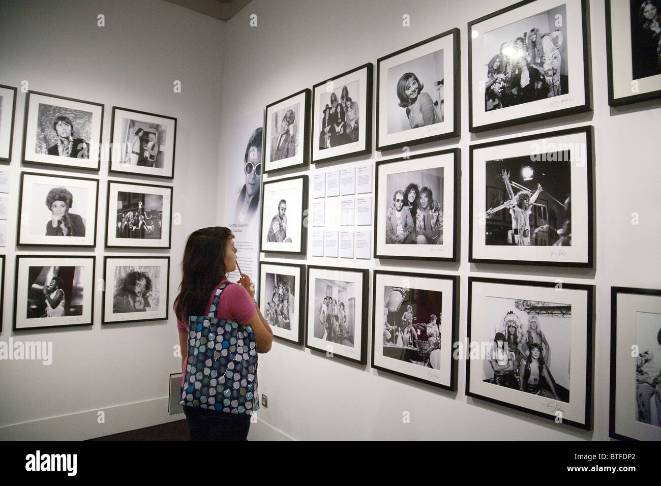 Un étudiant au niveau de la photographie à la recherche lors d'une exposition de photos, le Victoria and Albert Museum, Londres UK Banque D'Images