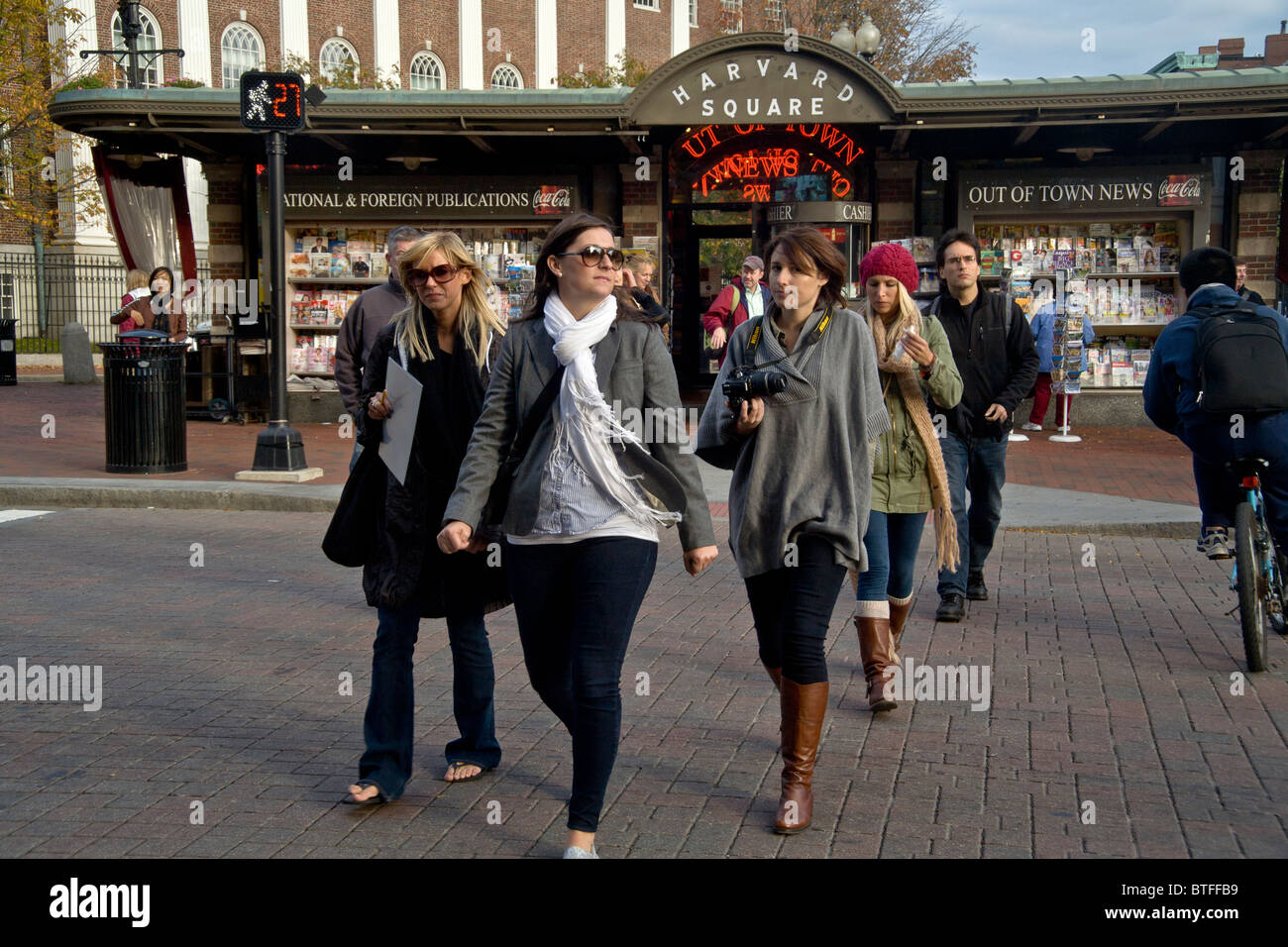 Les piétons traversent le Massachusetts Avenue à Harvard Square, Cambridge, MA. En arrière-plan est le kiosque à journaux et un bâtiment d'Harvard. Banque D'Images