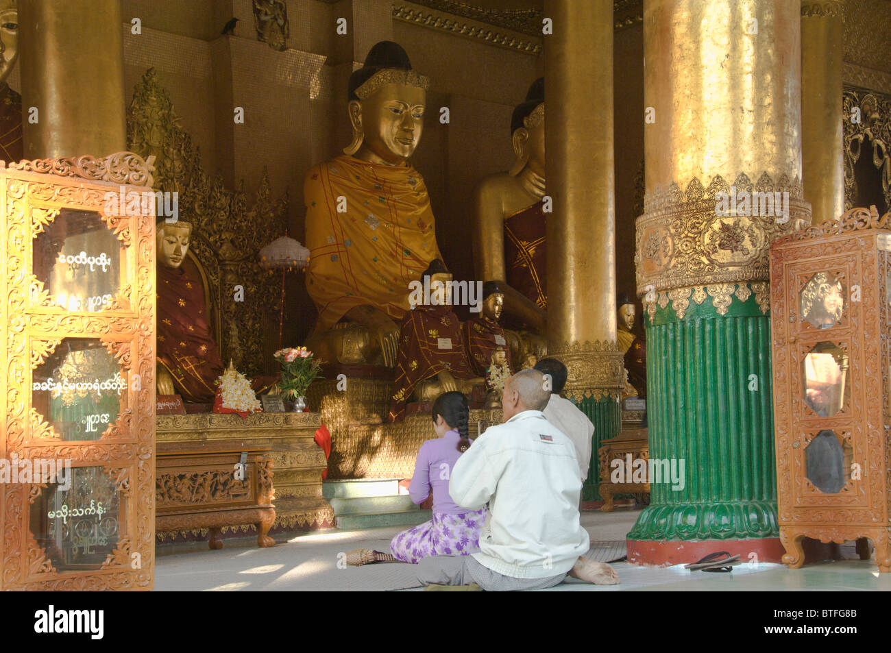 Les dévots prier dans le temple de la pagode Shwedagon, Bouddha Kakusandha, Yangon, Yangon, Birmanie, Myanmar Banque D'Images