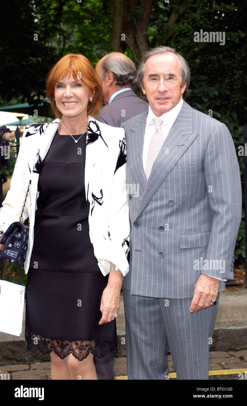 Pilote de course Jackie Stewart avec son bras autour de son épouse, Helen Stewart, arrivent pour partie dans Carlyle Square, Chelsea Banque D'Images