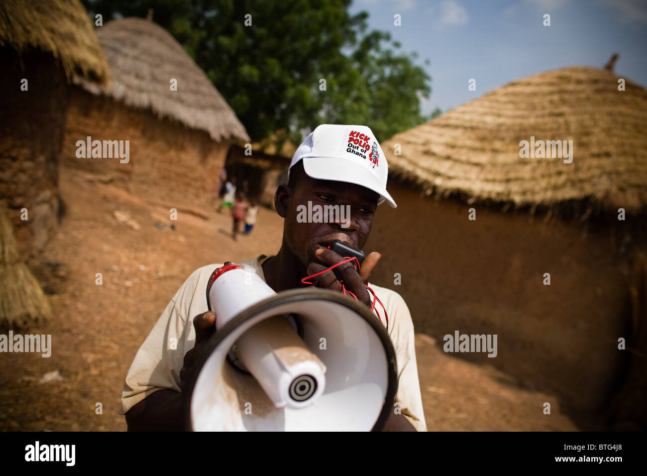 Un bénévole communautaire utilise un porte-voix pour annoncer une prochaine campagne de vaccination nationale Banque D'Images