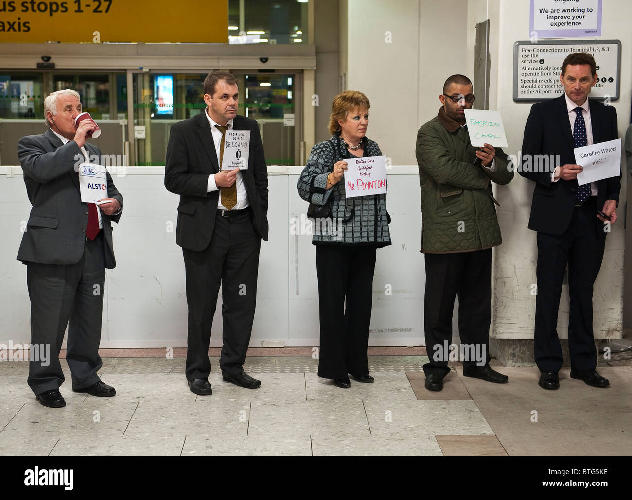 Chauffeurs de taxi attendant de rencontrer des passagers au terminal 4 de l'aéroport de Heathrow, Londres, Royaume-Uni Banque D'Images