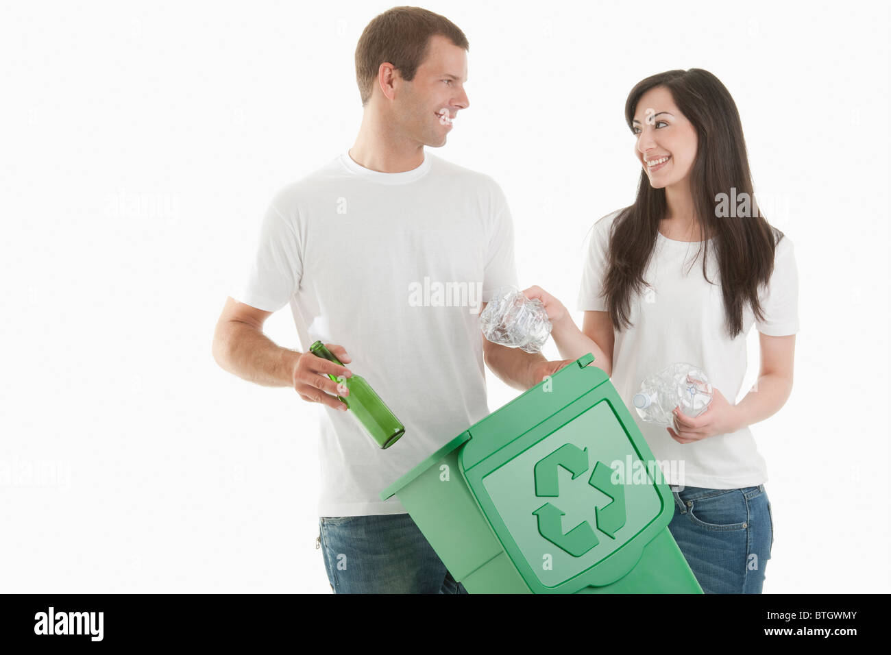Jeter quelques bouteilles en verre et en plastique dans le bac de recyclage Banque D'Images
