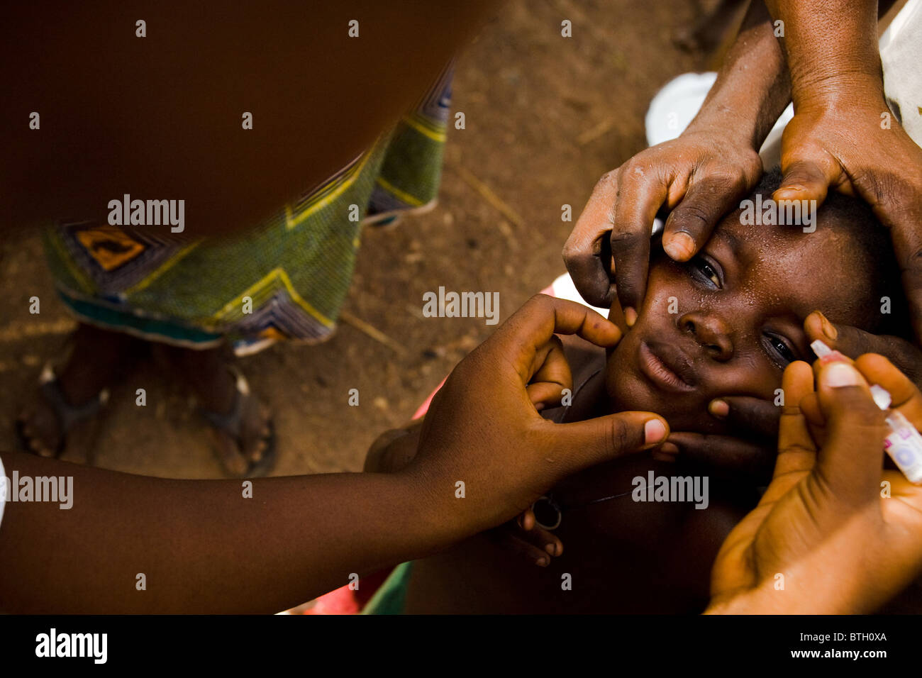 Un agent de santé vaccine un enfant contre la poliomyélite dans le village d'Gidan-Turu le nord du Ghana, le jeudi 26 mars 2009. Banque D'Images
