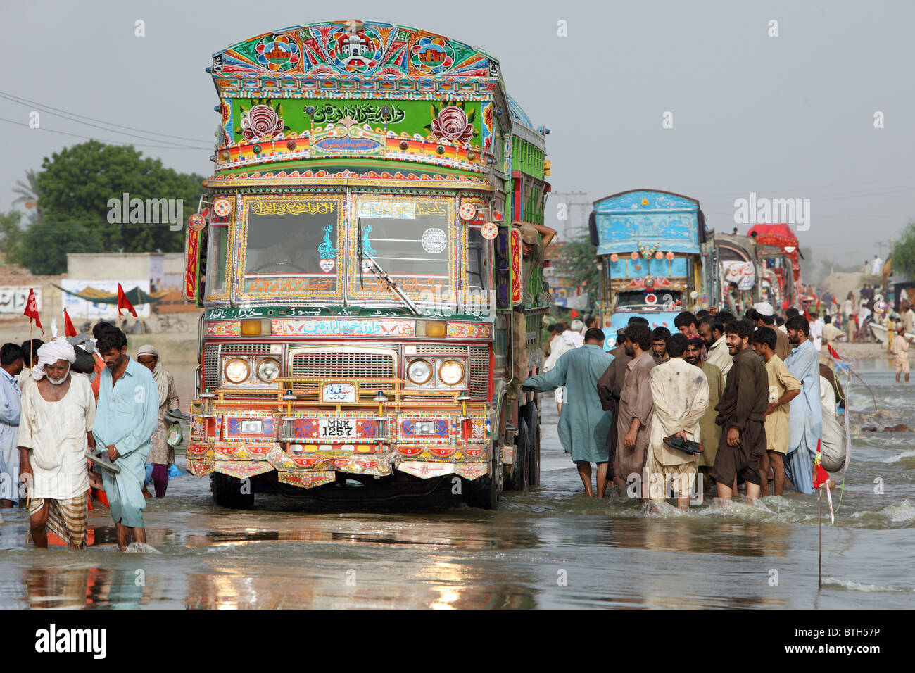 Les gens qui vont à travers l'inondation des rues, Muzaffargarh, Pakistan Banque D'Images