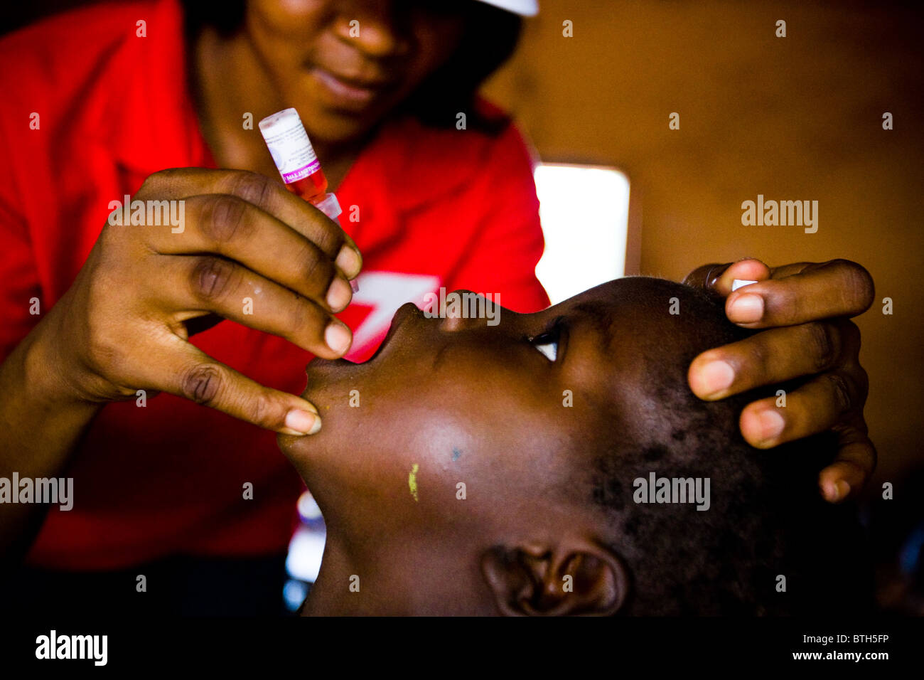 Un agent de santé vaccine un enfant pendant un exercice national de l'immunisation contre la polio à l'école primaire de Moglaa Banque D'Images
