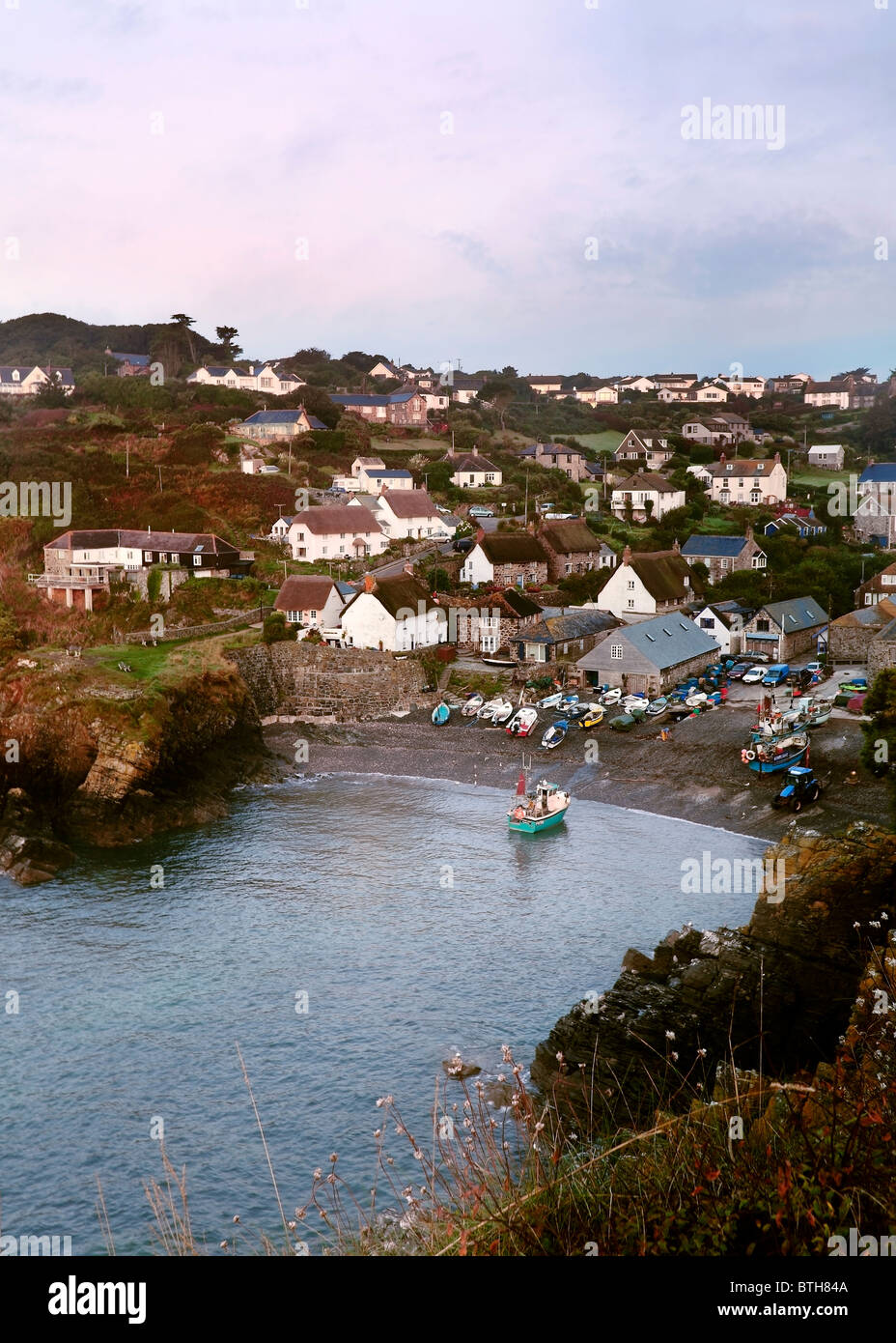 Un bateau de pêche arrive à la terre sur la plage de Cadgwith Cove, sur la Péninsule du Lézard de Cornwall. Banque D'Images
