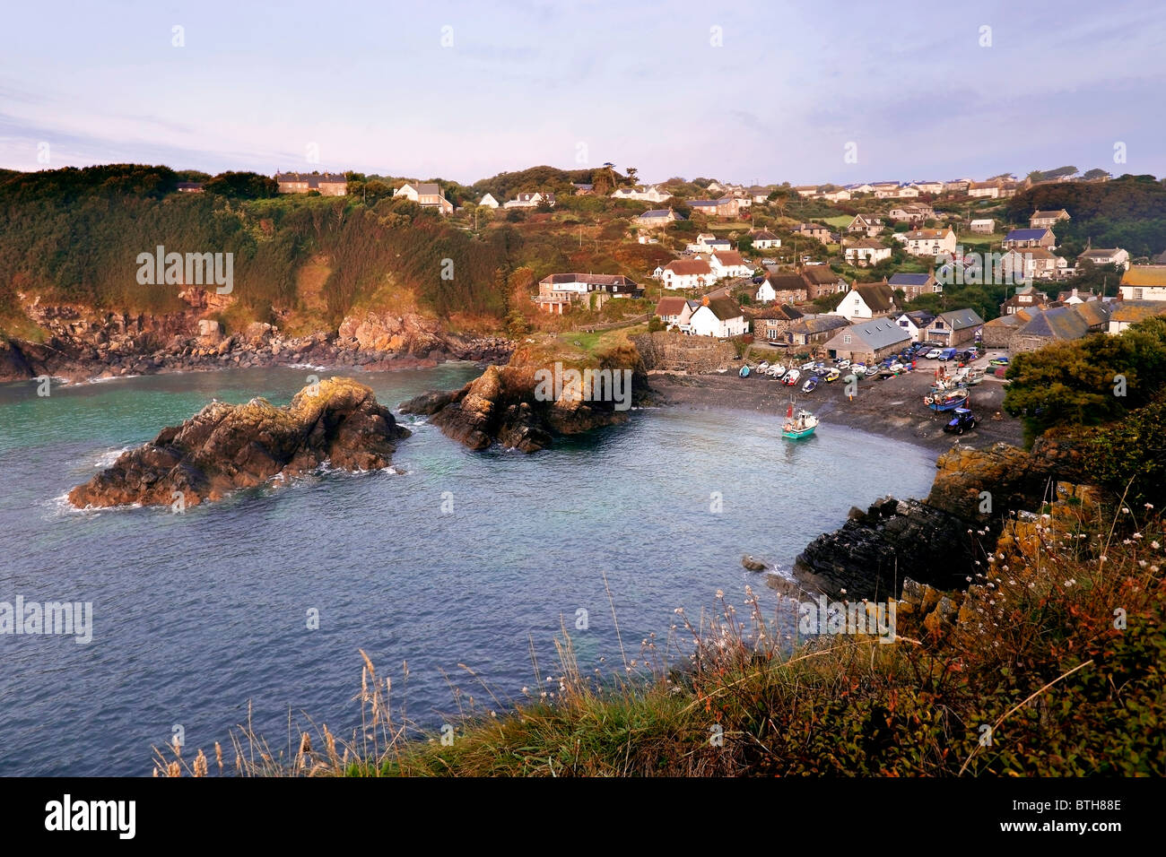 Tôt le matin, un bateau de pêche arrive sur terre au village de pêcheurs de Cornouailles, Cadgwith Cove. Banque D'Images