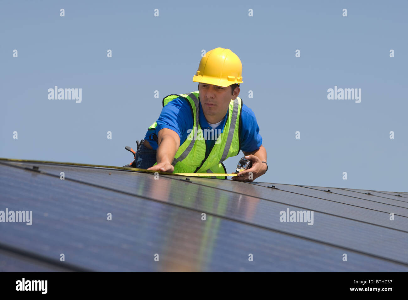 Ouvrier d'entretien des panneaux solaires sur le toit sur mesures, Los Angeles, Californie Banque D'Images