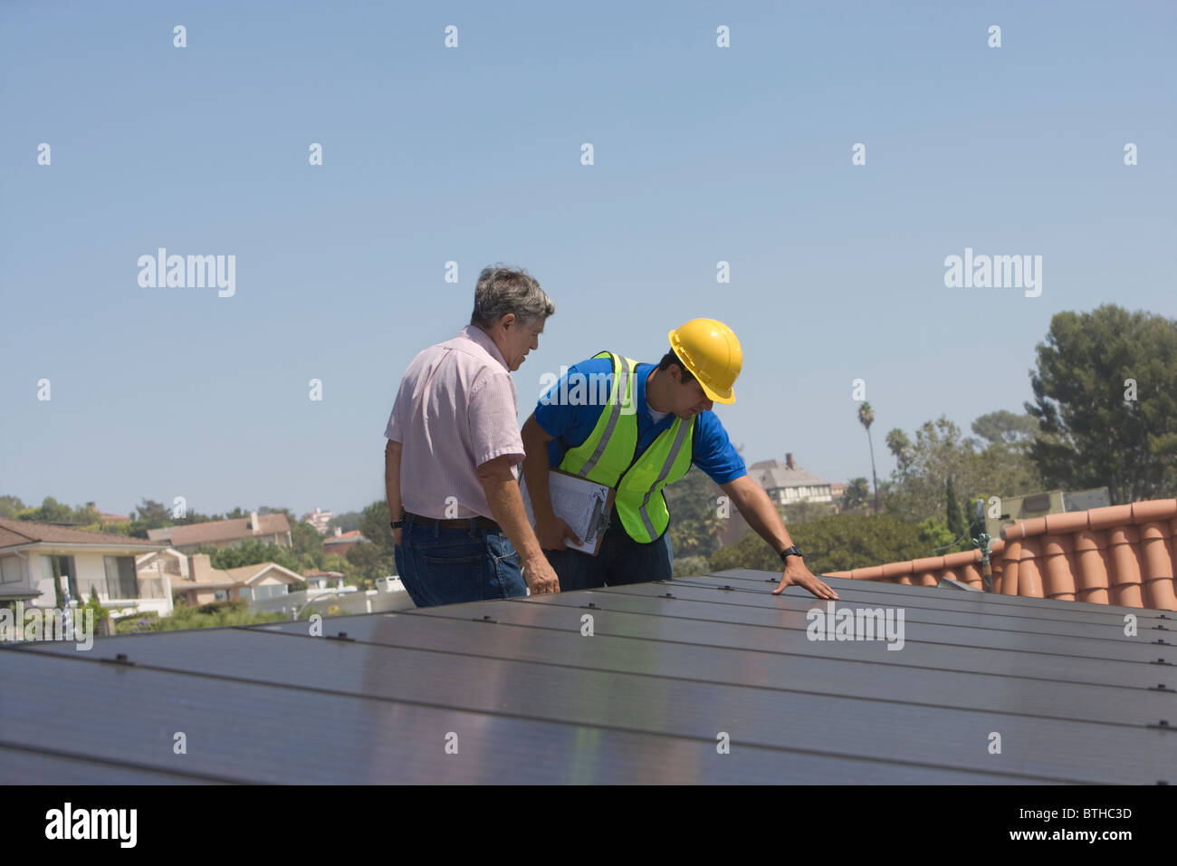 Les travailleurs d'entretien support avec batterie solaire sur toit à Los Angeles, Californie Banque D'Images