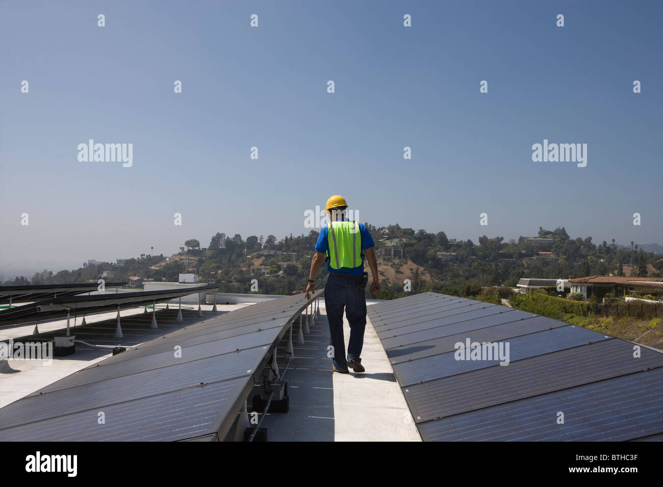 Ouvrier d'entretien vérifie la batterie solaire sur le toit à Los Angeles, Californie Banque D'Images