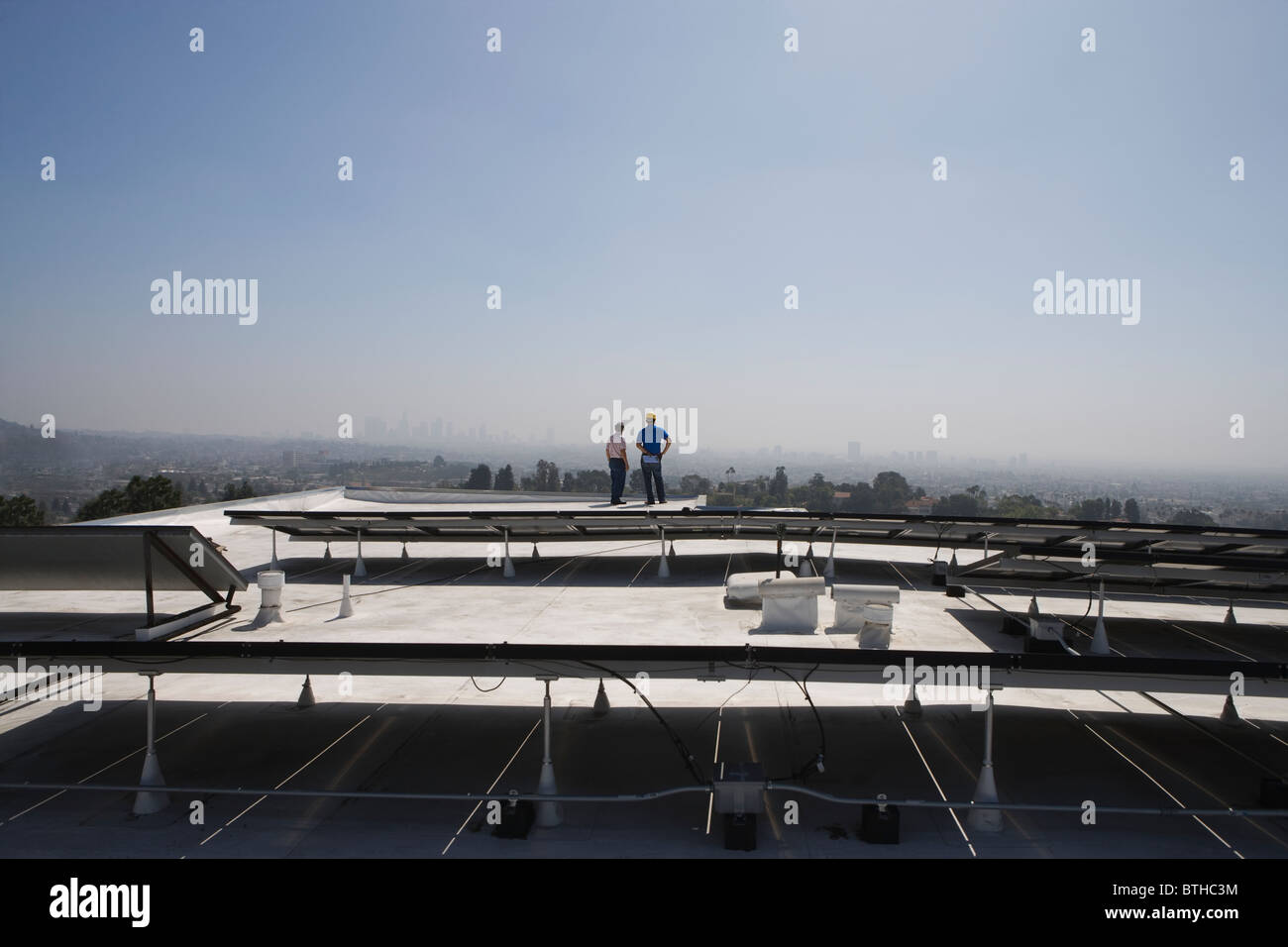Les travailleurs d'entretien support avec batterie solaire sur toit à Los Angeles, Californie Banque D'Images