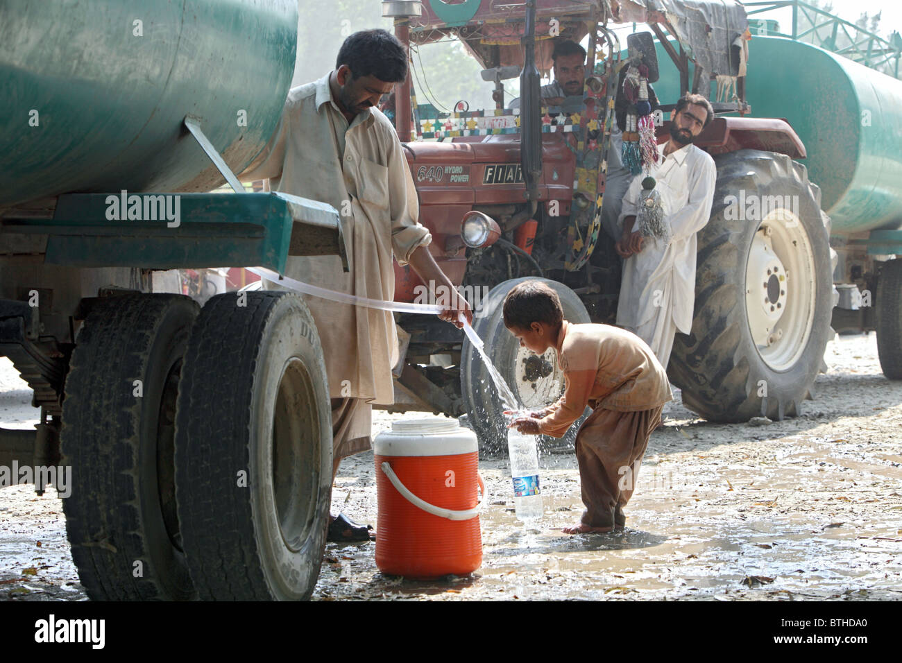 Un enfant de remplir une bouteille en plastique avec de l'eau potable, Charsadda, Pakistan Banque D'Images