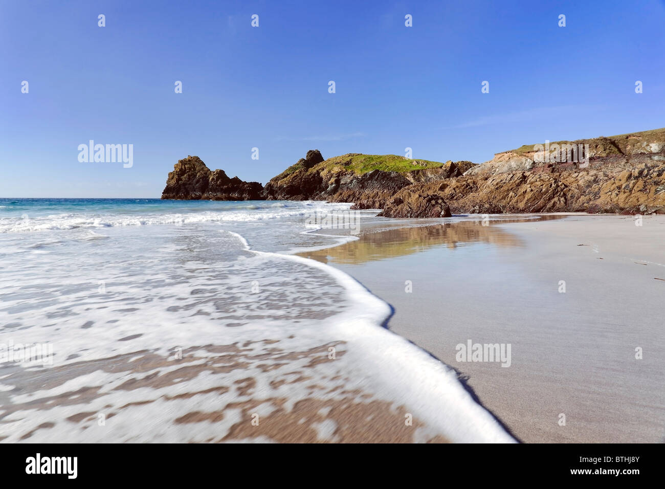 Surf blanc bulles sur les sables de Kynance Cove beach, le lézard, Cornwall Banque D'Images