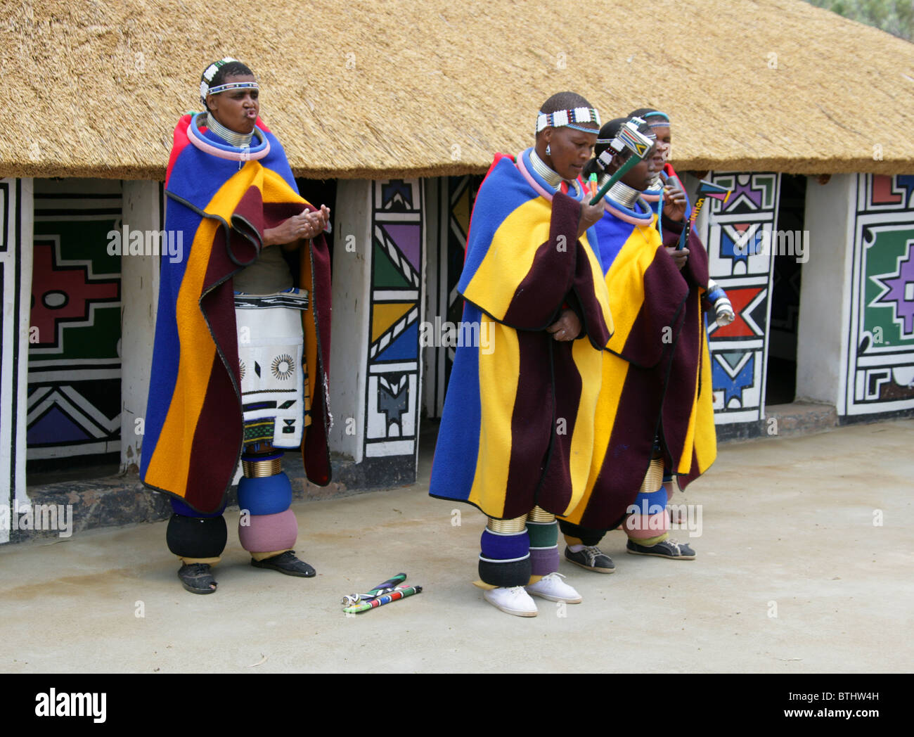 Les femmes Ndebele en costume traditionnel, Village Culturel Ndelebe, Botshabelo, Afrique du Sud. Chantant et jouant des instruments. Banque D'Images