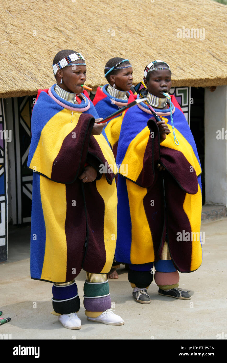 Les femmes Ndebele en costume traditionnel, Village Culturel Ndelebe, Botshabelo, Afrique du Sud. Chantant et jouant des instruments. Banque D'Images