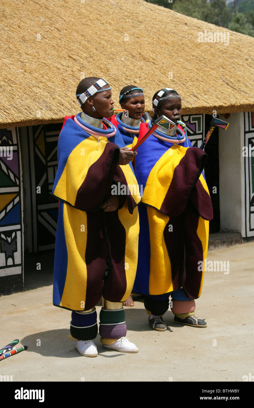 Les femmes Ndebele en costume traditionnel, Village Culturel Ndelebe, Botshabelo, Afrique du Sud. Chantant et jouant des instruments. Banque D'Images