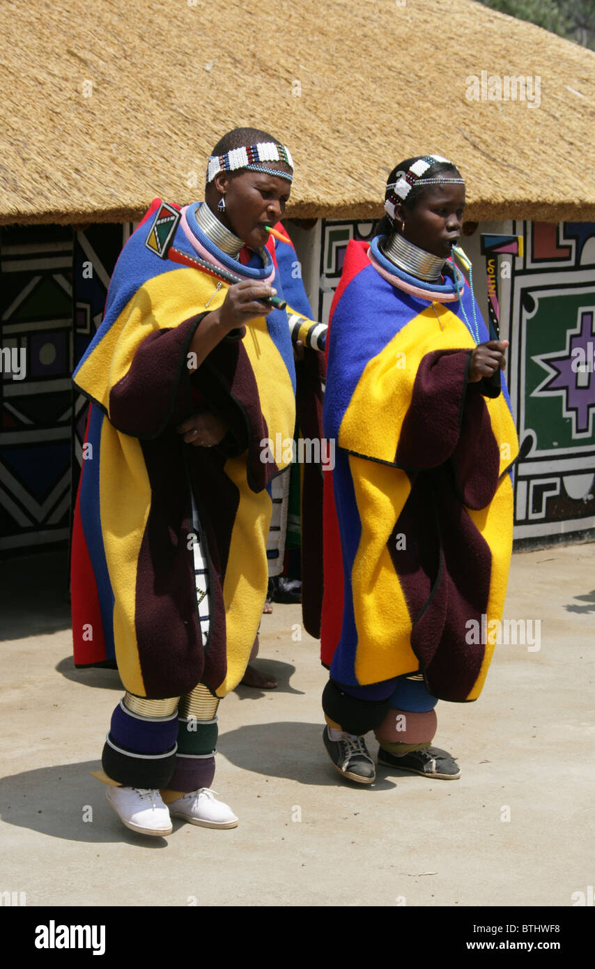 Les femmes Ndebele en costume traditionnel, Village Culturel Ndelebe, Botshabelo, Afrique du Sud. Chantant et jouant des instruments. Banque D'Images