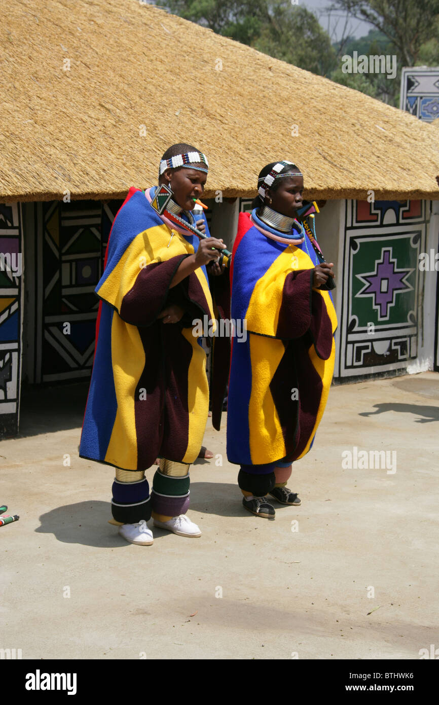 Les femmes Ndebele en costume traditionnel, Village Culturel Ndelebe, Botshabelo, Afrique du Sud. Chantant et jouant des instruments. Banque D'Images