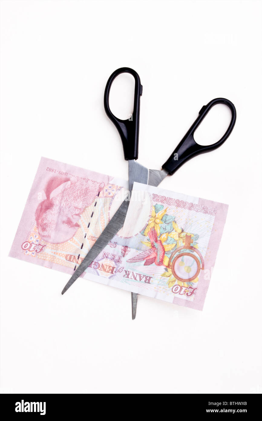 Paire de ciseaux coupant à travers un 10 livres sterling bank note Banque D'Images