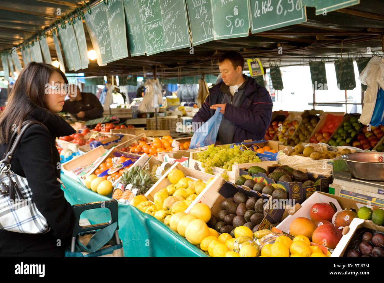 Une femme d'acheter des fruits à l'étal de l'épicerie, Coulommiers ville marché près de Paris, ile de france France Banque D'Images