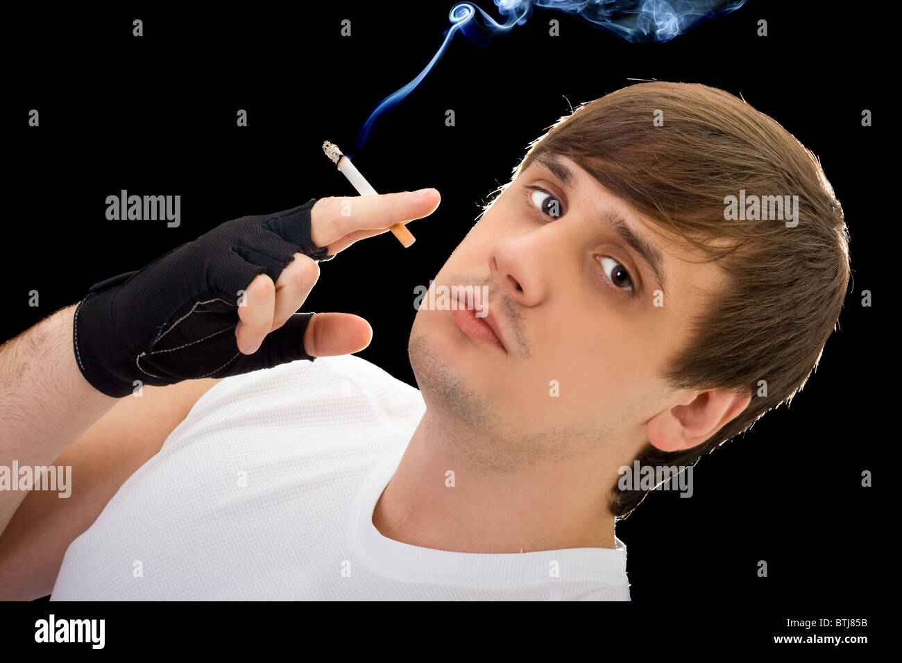 Jeune homme avec une cigarette. Isolated on black Banque D'Images