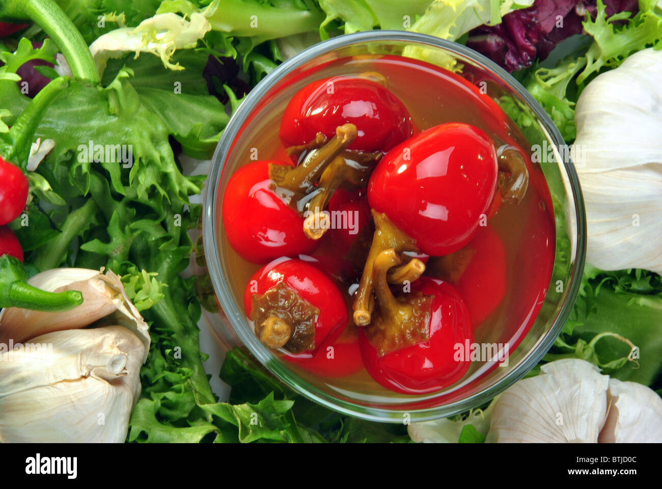 Paprika rouge cerise bio avec du vinaigre dans un verre Banque D'Images