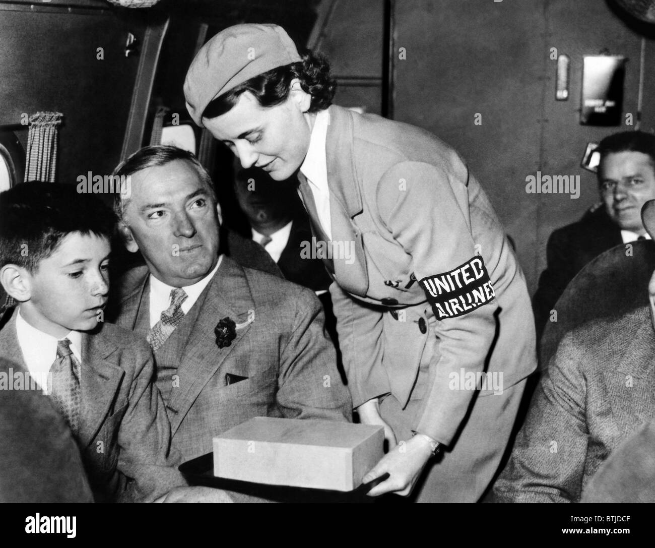 United Airlines stewardess assiste le maire James Curley de Boston. Il est devenu le gouverneur de Massachusettes, 1934. Cour Banque D'Images