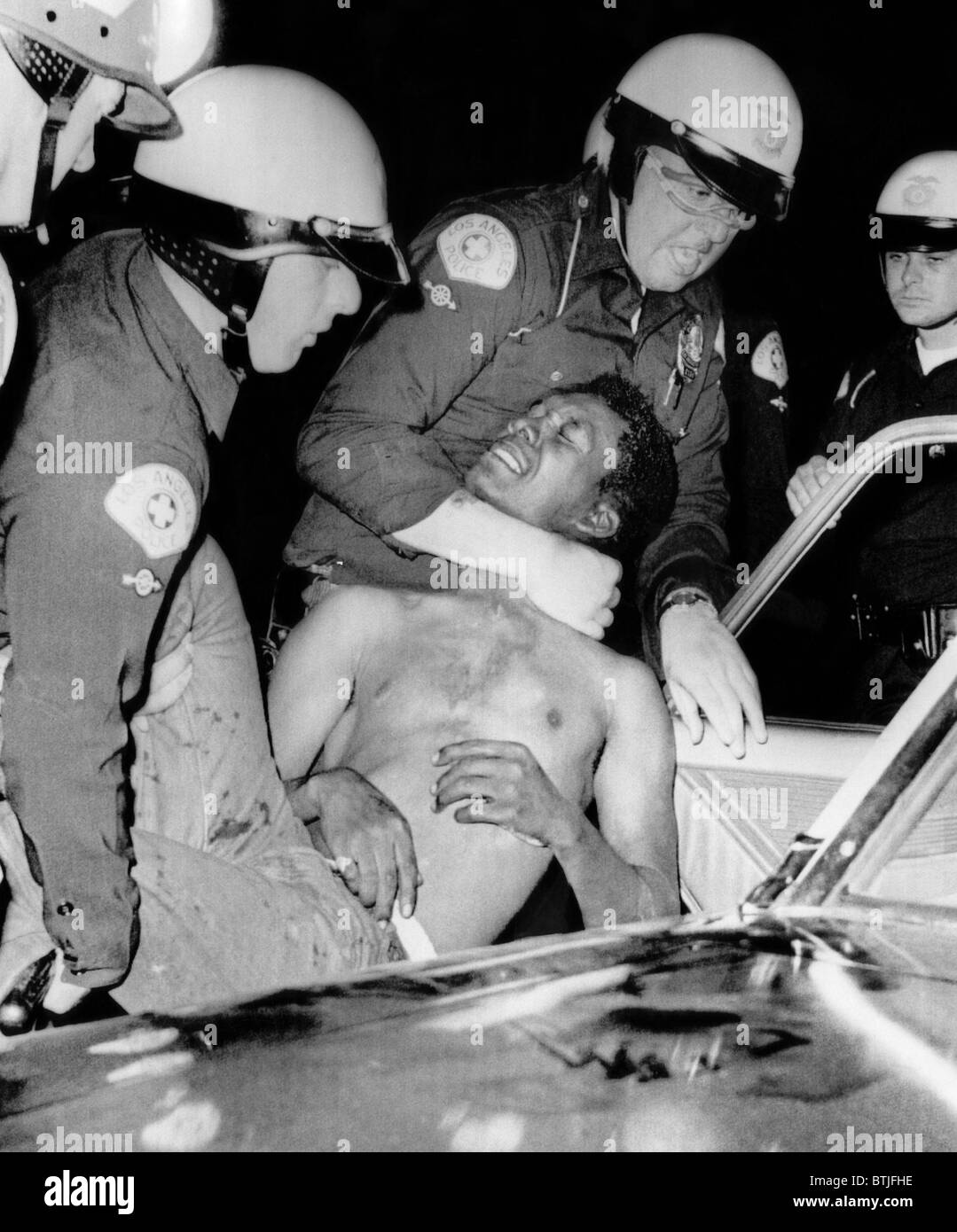 La force de police un homme dans une voiture de police lors des émeutes de Watts, 1965. Avec la permission de : Archives CSU/Everett Collection Banque D'Images