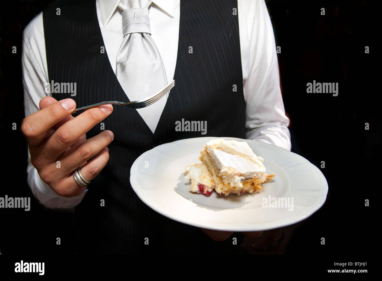 Groom eating cake Banque D'Images