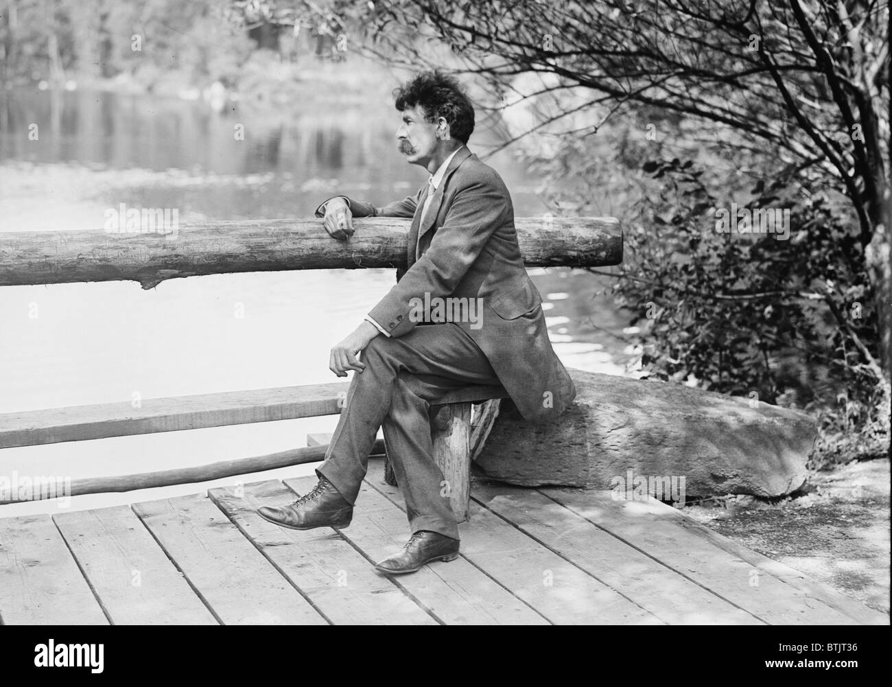 Ernest Thompson Seton (1860-1946), naturaliste et écrivain canadien, assis sur un banc au bord du lac. Probablement à New York's Central Park, ca. 1910. Banque D'Images