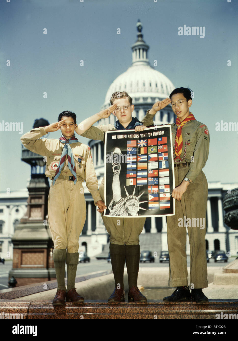 La Seconde Guerre mondiale, trois scouts de garçon avec une Organisation des Nations Unies pour l'affiche en face du Capitole, titre original : "Lutter pour la liberté de l'Organisation des Nations Unies de couleur : blanc, Chinois et les Scouts en face de Capitol, ils aident à bien par la prestation de poster pour participer à l'effort de guerre", Washington DC, photo de John Rous, juillet 1941. Banque D'Images