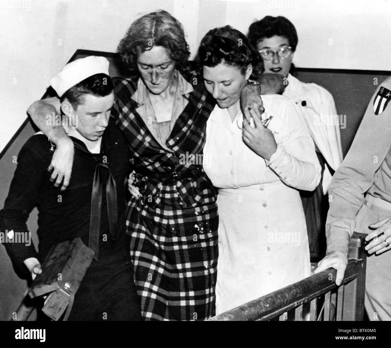 Don Molony, un garde-côte américain de 17 ans, contribue à une femme blessée dans les escaliers dans la Empire State Building le matin Banque D'Images