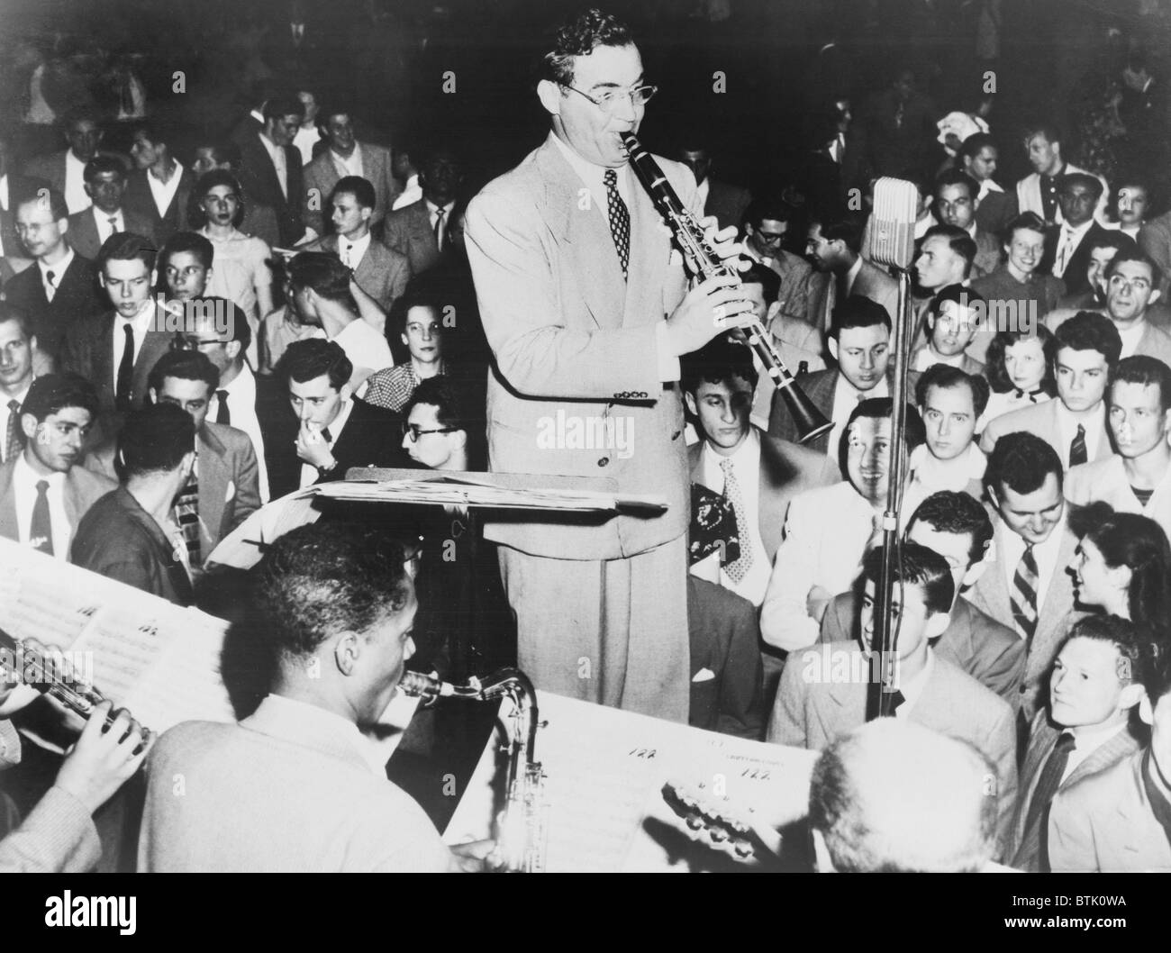 Benny Goodman (1909-86), jouant la clarinette, admirateurs regardez et écoutez. Goodman's Swing dance music a tant aimé, les danseurs s'arrêta pour se concentrer sur la musique. 1938. Banque D'Images