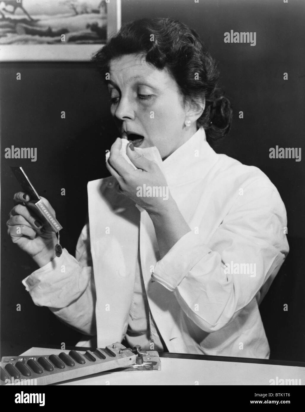 Hazel Bishop (1906-1998) est surtout connu pour la marque de cosmétiques qui porte son nom. Moins connu est son travail en tant que scientifique, femmes d'affaires, et enfin un analyste financier à Wall Street. 1951 L'Évêque photo montre l'application de sa nouvelle 'rouge à lèvres durable." Banque D'Images