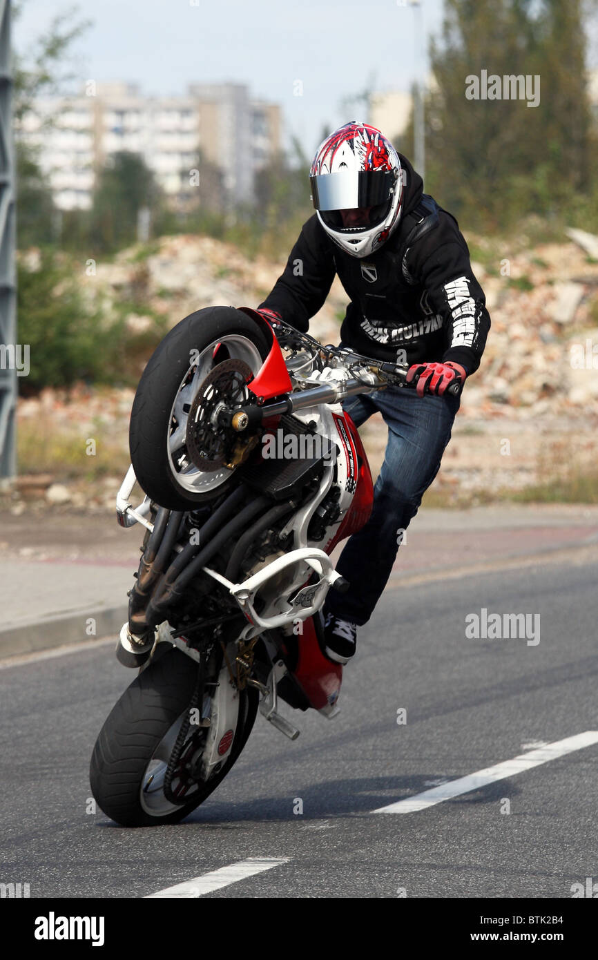 Stunt motorbiker en équilibre sur sa Honda moto sur roue arrière Photo  Stock - Alamy